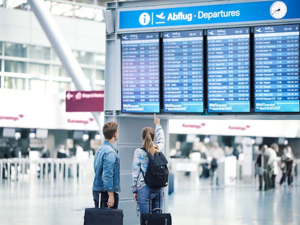 A woman and a man in front of the information board at Cologne/Bonn Airport