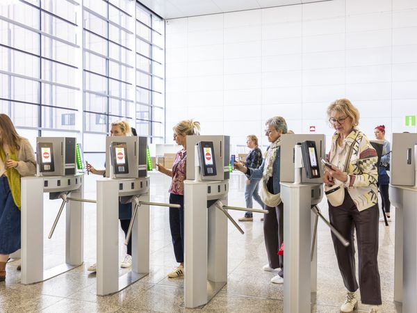 People walk through the digital entrance of Koelnmesse