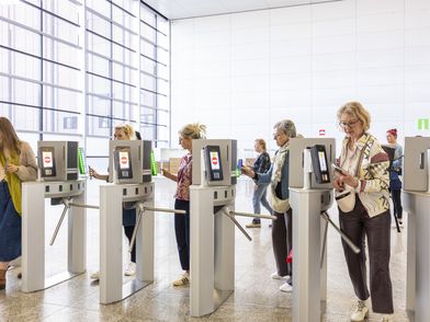 People walk through the digital entrance of Koelnmesse