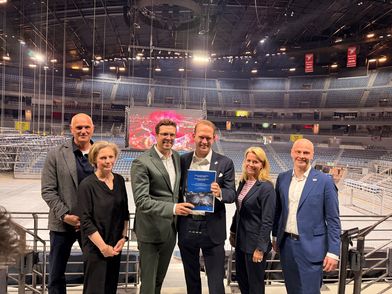 Dr. Christoph Bertling (Vertreter DSHS), Dr. Inga Oelrichs (Vertreterin DSHS), Andree Haack (Wirtschaftsdezernent Stadt Köln), Stefan Löcher (Geschäftsführer AMG), Stephanie Kleine-Klausing (Geschäftsführerin Kölntourismus) und Tomasz Grenke (Kommunikationsleitung LANXESS arena) standing inside of LANXESS arena Cologne
