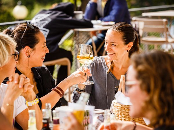 Company picnic at Dank Augusta: A group of women toast with sparkling wine.