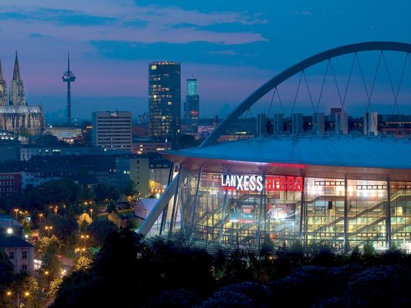 Lanxess Arena with Cologne Cathedral in the background at night