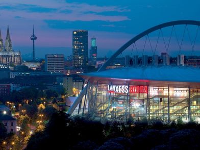 Lanxess Arena with Cologne Cathedral in the background at night