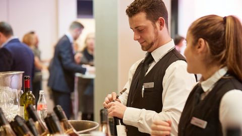 Event staff opening wine bottles