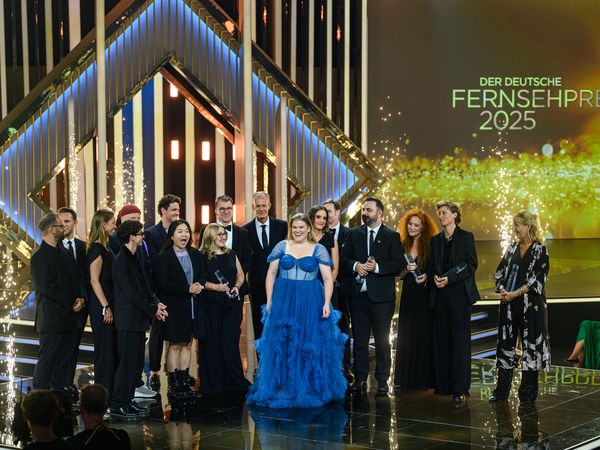 Stars in suits and dresses on stage at the award show "Deutscher Fernsehpreis 2025"