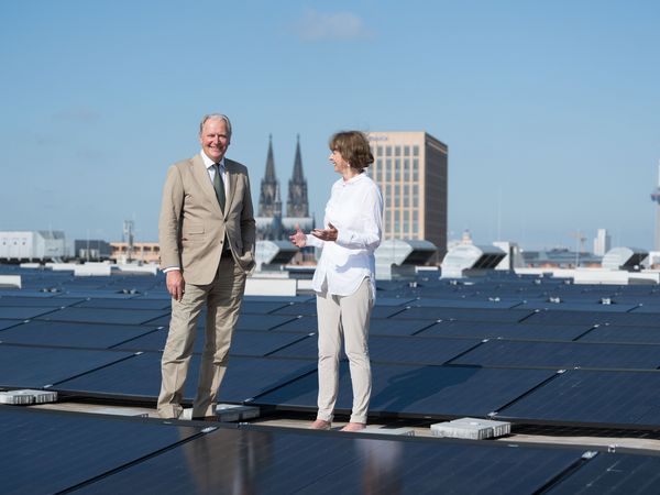 The managing director of Koelnmesse and the mayor of Cologne stand on the roof of Koelnmesse among numerous solar panels for the inauguration of Cologne's largest inner-city solar power installation.